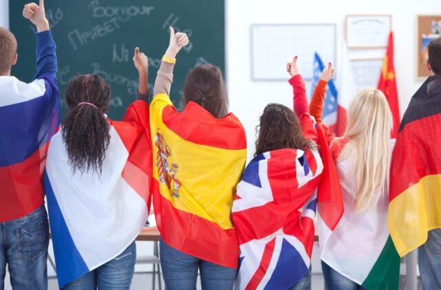 Szkoła języków obcych, dzieci z flagami różnych krajów.