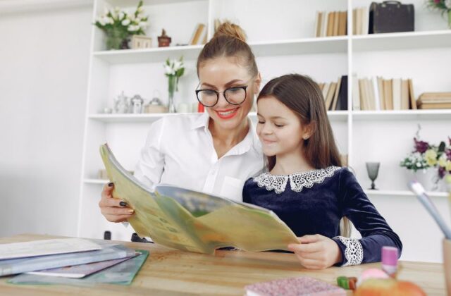 Czy praca domowa jest obowiązkowa? Na zdjęciu mama rozwiązuje zadanie domowe z córką.